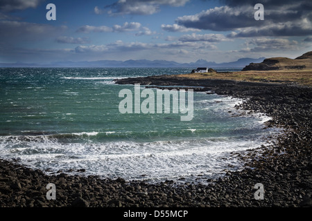 Tradizionale imbiancato croft sulle rive della Baia di Kilmaluag, Isola di Skye in Scozia Foto Stock