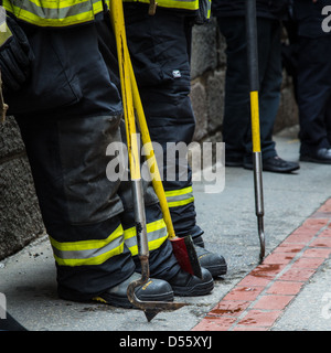 I vigili del fuoco stanno intorno in attesa di un tutto chiaro in un hotel di allarme incendio. Raccoglie e assi penzolanti. Foto Stock