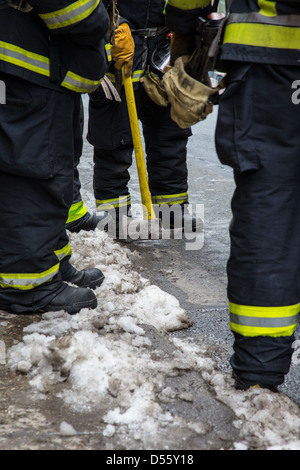 I vigili del fuoco stanno intorno in attesa di un tutto chiaro in un hotel di allarme incendio. Raccoglie e assi penzolanti. Foto Stock