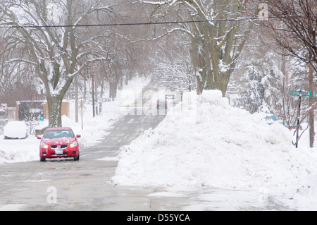 Una tempesta di neve in inverno lascia un piede di neve su una piccola città Illinois e gli aratri lasciare enormi cumuli di neve Foto Stock