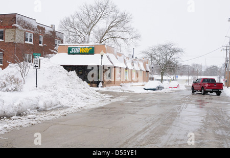 Una tempesta di neve in inverno lascia un piede di neve su una piccola città Illinois e gli aratri lasciare enormi cumuli di neve Foto Stock