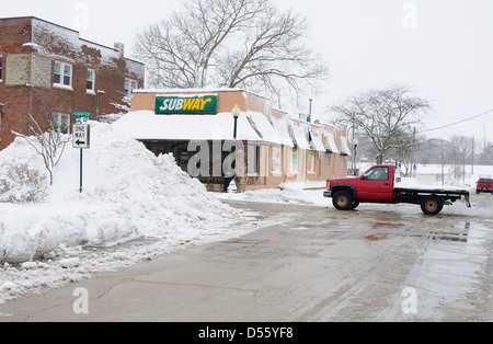 Una tempesta di neve in inverno lascia un piede di neve su una piccola città Illinois e gli aratri lasciare enormi cumuli di neve Foto Stock