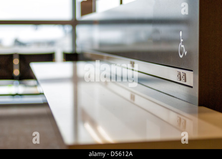 Aeroporto stazione di alimentazione per ricaricare i telefoni che è accessibile ai portatori di handicap Foto Stock