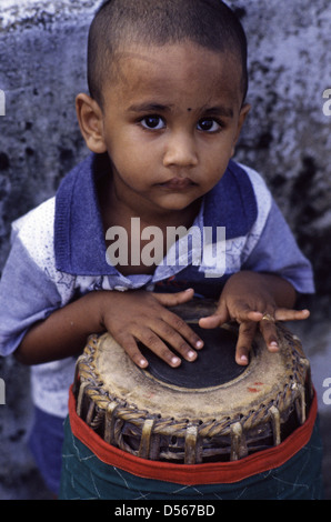 Giovane ragazzo giocando tradizionale tabella Mridangam tamburo in Tamil Nadu India del Sud Foto Stock