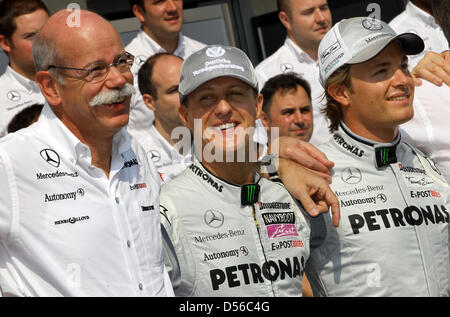 (L a R:) Presidente della Daimler AG e la testa di Mercedes-Benz Cars Dieter Zetsche sorge accanto al tedesco della Mercedes GP piloti Michael Schumacher e Nico Rosberg prima che il titolo sia decisiva 2010 Formula Uno stagione finale a Yas Marina Circuit Race Track in Abu Dhabi, Emirati Arabi Uniti, 14 novembre 2010. Nella sessione di qualifica, il tedesco Vettel della Red Bull aveva sostenuto la pole position a Foto Stock