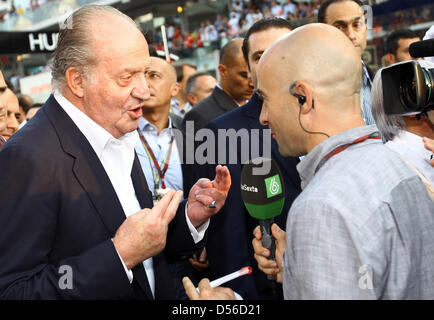 Il re Juan Carlos di Spagna (L) dà un intervista ad un giornalista spagnolo nella griglia del Gran Premio di Abu Dhabi a Yas Marina Circuit di Abu Dhabi, Emirati Arabi Uniti, 14 novembre 2010. Vincere la Formula 1 Gran Premio di Abu Dhabi, il tedesco Sebastian Vettel della Red Bull Racing aveva conquistato il titolo e diventa il più giovane in assoluto campione del mondo. Foto: Jens Buettner Foto Stock