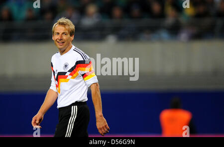 Jürgen Klinsmann von der WM-Mannschaft von 1990 schaut am Samstag (20.11.2010) im Rahmen des 'Spiel der Legenden' in der Red Bull Arena di Lipsia amüsiert Spiel dem zu. In der sächsischen Messestadt trifft un diesem Tag eine Auswahl des Weltmeister-Teams der BRD von 1990 auf die Spieler der damaligen DDR-Auswahl, um zwanzig Jahre Wiedervereinigung im deutschen Fußball zu feiern. F Foto Stock