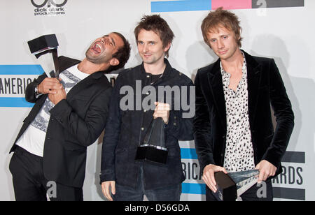 British rock band Muse con (L-R) Christopher Wolstenholme, Matthew Bellamy e Dominic Howard mostrano il loro premio preferito per la musica rock alternativa artista alla trentottesima annuale degli American Music Awards a Los Angeles, California, USA, 21 novembre 2010. Foto: Hubert Boesl Foto Stock