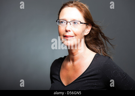 Felice donna spontanea. Con gli occhiali. Studio shot. Foto Stock