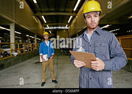 Lavoratori caucasici con cartelline in magazzino Foto Stock