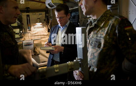 Verteidigungsminister Karl-Theodor zu Guttenberg (CSU, M.) steht am Montag (29.03.10) auf dem Weg von Berlin nach Pristina im Kosovo in einem Transportflugzeug der Bundeswehr. Im Rahmen eines Besuchs zweitaegigen im Kosovo und in Bosnien-Herzegowina trifft zu Guttenberg die dort stationierten Soldaten der Missionen EUFOR und KFOR. Foto: Michael Kappeler/DDP Foto Stock