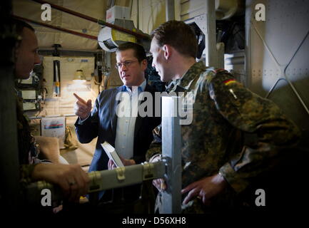 Verteidigungsminister Karl-Theodor zu Guttenberg (CSU, M.) steht am Montag (29.03.10) auf dem Weg von Berlin nach Pristina im Kosovo in einem Transportflugzeug der Bundeswehr. Im Rahmen eines Besuchs zweitaegigen im Kosovo und in Bosnien-Herzegowina trifft zu Guttenberg die dort stationierten Soldaten der Missionen EUFOR und KFOR. Foto: Michael Kappeler/DDP Foto Stock