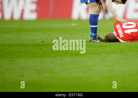 Berlinese di Arne FRIEDRICH (L) assiste a Colonia di Lukas Podolski giacente sul passo del dolore durante la Bundesliga partita di calcio FC Colonia vs Hertha Berlino presso RheinEnergieStadium a Colonia, Germania, 03 aprile 2010. Foto: Rolf Vennenbernd Foto Stock