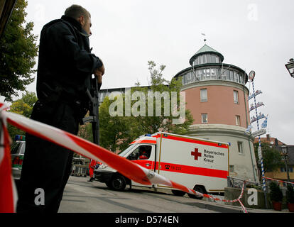 (Dpa) file di un file immagine datata 17 settembre 2009 dell' agente di polizia armato custodire i locali mentre un ambulanza lascia la scuola Carolinum a Ansbach, Germania. Una pupilla accusato di essere responsabile per la rampage riprese presso la scuola dovrà affrontare la corte dal 22 aprile 2010. Il periodo di prova a divisione giovanile di Ansbach district court vedrà quattro giorni di prova, tre di loro schedu Foto Stock