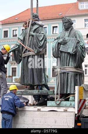 Un memoriale di Philipp Melantone (L) viene caricato su un camion vicino al memoriale di Martin Lutero a Wittenberg (Germania), 22 aprile 2010. I monumenti commemorativi del reformer Luther (1483-1546) e il suo compagno i diruttori Melantone (1497-1560) sarà rinnovato per 1.2 milioni di euro. Entrambi i memoriali tornerà sul giorno della riforma il 31 ottobre 2010. Fino ad allora, artista Ottmar Hoerl riempirà th Foto Stock