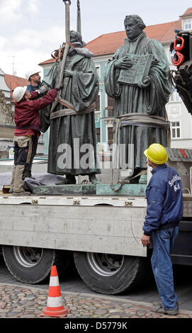 Un memoriale di Philipp Melantone (L) viene caricato su un camion vicino al memoriale di Martin Lutero a Wittenberg (Germania), 22 aprile 2010. I monumenti commemorativi del reformer Luther (1483-1546) e il suo compagno i diruttori Melantone (1497-1560) sarà rinnovato per 1.2 milioni di euro. Entrambi i memoriali tornerà sul giorno della riforma il 31 ottobre 2010. Fino ad allora, artista Ottmar Hoerl riempirà th Foto Stock