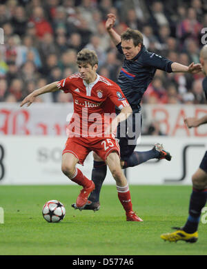 Monaco di Baviera Thomas Mueller (L) comanda la sfera durante la UEFA Champions League semi-finale prima gamba match tra Bundesliga tedesca club FC Bayern Monaco e lato Francese Olympique Lyonnais a stadio Allianz Arena di Monaco di Baviera, Germania, 21 aprile 2010. Il Bayern Monaco sconfitto Lyon 1-0. La seconda gamba match avrà luogo a Lione, in Francia il 27 aprile 2010. Foto: Lukas Barth Foto Stock