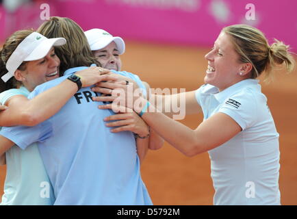 In Francia i giocatori di Julie Coin, Alizé CORNET e Pauline Parmentier (L-R) allietare con il capitano di una squadra Nicolas Escudé dopo la loro vittoria in Fed Cup gioco di retrocessione Germania vs Francia in Frankfurt/Main, Germania, 25 aprile 2010. Con una vittoria 3-2 sopra la Germania, la Francia rimane nel tennis world group. Foto: Arne Dedert Foto Stock