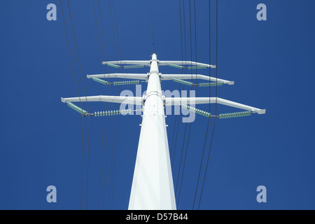 Bianco ad alta tensione pilone di elettricità contro il profondo blu del cielo, da sotto. Foto Stock