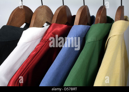 Uomo di abbigliamento: scelta di eleganti camicie colorate su portabiti in legno. Foto Stock