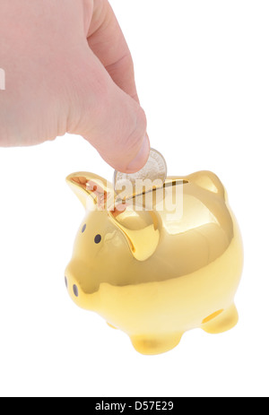 La caduta di mano il denaro in un golden piggybank isolato su bianco Foto Stock