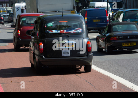 Nero con taxi guidando lungo una strada della città di Londra, Inghilterra. Foto Stock