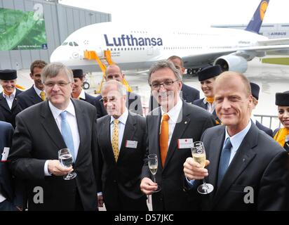 Il segretario di Stato parlamentare Peter Hintze (L-R), Lufthansa presidente del consiglio di sorveglianza Juergen Weber, CEO Wolfgang Mayrhuber e Airbus CEO Thomas Enders bere champagne per la distribuzione del primo A380 aeroplano di Lufthansa all'Airbus posizione ad Amburgo, Germania, 19 maggio 2010. L'Airbus A380 è chiamato 'Frankfurt am Main', è 72 metri di lunghezza e può ospitare 526 passenge Foto Stock