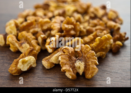 Noci sgusciate sono sul piccolo mucchio di marrone tavolo in legno Foto Stock