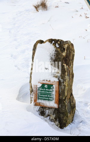 Casella di donazione in una pietra per raccogliere denaro per il sentiero pubblico opera nel Parco Nazionale di Snowdonia, il Galles del Nord, Regno Unito, Gran Bretagna Foto Stock