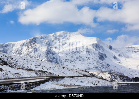 Vista su tutta Llyn Ogwen lago a Y Garn montagna con cornici di neve sulla cresta in inverno nelle montagne del Parco Nazionale di Snowdonia, Galles del Nord, Regno Unito Foto Stock