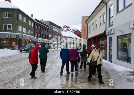 La gente camminare lungo coperto di ghiaccio storgata strada principale dello shopping di Honningsvag finnmark Norvegia europa Foto Stock