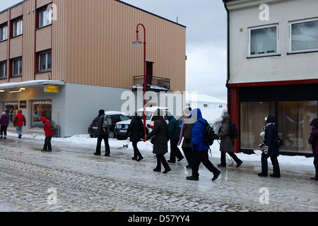 La gente camminare lungo coperto di ghiaccio storgata strada principale dello shopping di Honningsvag finnmark Norvegia europa Foto Stock