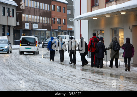 La gente camminare lungo coperto di ghiaccio storgata strada principale dello shopping di Honningsvag finnmark Norvegia europa Foto Stock