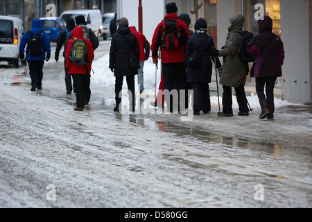 La gente camminare lungo coperto di ghiaccio storgata strada principale dello shopping di Honningsvag finnmark Norvegia europa Foto Stock