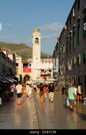 I turisti a piedi lungo il Stradun in serata nel paese vecchio di Dubrovnik con il campanile cittadino in background, Croazia Foto Stock