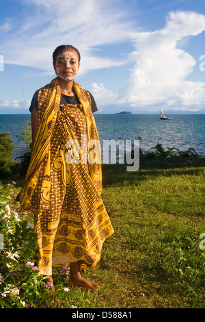 Donna malgascia di etnia Sakalava con tradizionale maschera di vernice a Nosy Be Island, a nord del Madagascar. Foto Stock