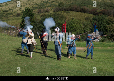 Un gruppo di guerra civile inglese re-enactors in uniformi di Royalist moschettieri fuoco le loro armi. Corfe Castle nel Dorset. Inghilterra, Regno Unito " Foto Stock