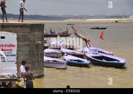 Giovane uomo di saltare nel fiume Gange a Varanasi Foto Stock