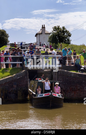 Narrowboat che esce dalla chiusa in una giornata intensa a Foxton Locks, Grand Union Canal, Market Harborough, Leicestershire, Inghilterra, REGNO UNITO Foto Stock