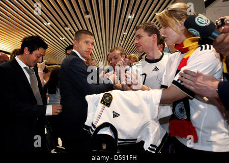 FRANKFURT AM MAIN, Germania - 06 giugno: Lukas Podolski firma autografi sul suo modo di salire a bordo durante un evento della ventola prima della partenza della squadra nazionale di calcio tedesca ai mondiali di calcio FIFA 2010 in Sud Africa all'aeroporto internazionale il 6 giugno 2010 in Frankfurt am Main, Germania. Foto: Alex Grimm dpa Foto Stock