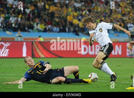 Thomas Mueller (R) il sistema VIES con Scott Chipperfield di Australia durante la Coppa del Mondo FIFA 2010 GRUPPO D match tra Germania e Australia a Mosè Mabhida Stadium di Durban, Sud Africa, 13 giugno 2010. Foto: Bernd Weißbrod dpa si prega di fare riferimento a http://dpaq.de/FIFA-WM2010-TC +++(c) dpa - Bildfunk+++ Foto Stock