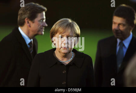 Il cancelliere tedesco Angela Merkel, suo marito Joachim Sauer (R) e il Ministro degli esteri tedesco Guido Westerwelle (L) partecipare alla grande tattoo per i messaggi in uscita il Presidente tedesco Koehler presso la sua residenza il palazzo Bellevue a Berlino, Germania, 15 giugno 2010. La Koehler sorprendentemente rassegnato le dimissioni dal suo ufficio con effetto immediato a fine maggio. Foto: Wolfgang Kumm Foto Stock