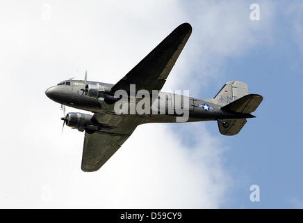 (Dpa) file di un file immagine datata 12 maggio 2009 di un Douglas DC-3 Dakota su Berlino, Germania. I vigili del fuoco di esaminare un passito si è schiantato bombardiere, aka bombardiere di caramella in un campo nei pressi di Schoenefeld, Germania, 19 giugno 2010. Quattro dei 25 passeggeri sono rimasti feriti in atterraggio di emergenza. La storica aereo si è schiantato ancora motivi di incertezza dopo il decollo. Foto: Wolfgang Kumm Foto Stock