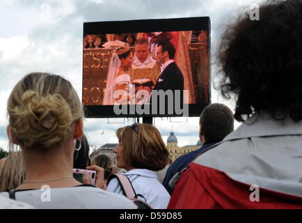 Spettatori guarda le nozze della corona svedese Principessa Victoria e Prince Daniel della Svezia, il Duca di Vastergotland, su un grande schermo di fronte al Palazzo Reale di Stoccolma, Svezia, 19 giugno 2010. Foto: CARSTEN REHDER Foto Stock