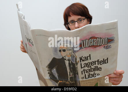 22 giugno 2010, una giovane donna legge il numero corrente del quotidiano francese "liberazione". Eventi giornalieri sono illustrati dalla stilista Karl Lagerfeld in oggi il quotidiano parigino. Foto: Soeren Stache dpa/Ibn (Zu dpa 391 del 22.06.2010) Foto Stock