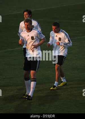 La Germania Per Mertesacker (L-R), Mesut Oezil e Lukas Podolski durante una sessione di allenamento della nazionale tedesca di calcio al Super Stadium di Atteridgeville vicino a Pretoria, Sud Africa, 25 giugno 2010. Foto: Marcus Brandt dpa Foto Stock