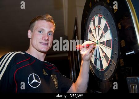 Marcell Jansen del tedesco di calcio team tira fuori la sua freccia del bersaglio del centro di elettronica di gioco di freccette in Velmore Grande Hotel in Erasmia/Centurion, Sud Africa, 24 giugno 2010. La partita contro l'Inghilterra del round degli ultimi sedici potrebbe essere una buona occasione per Jansen. Tre mesi dopo il suo piede lesioni, il lettore di Amburgo è pronto per la grande sfida contro Foto Stock