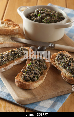 Nero oliva tapenade sul pane francese tostato Foto Stock