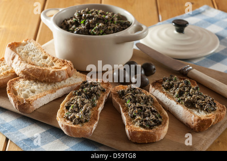 Nero oliva tapenade sul pane francese tostato Foto Stock