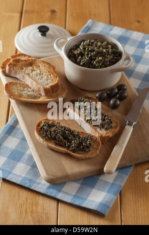 Nero oliva tapenade sul pane francese tostato Foto Stock